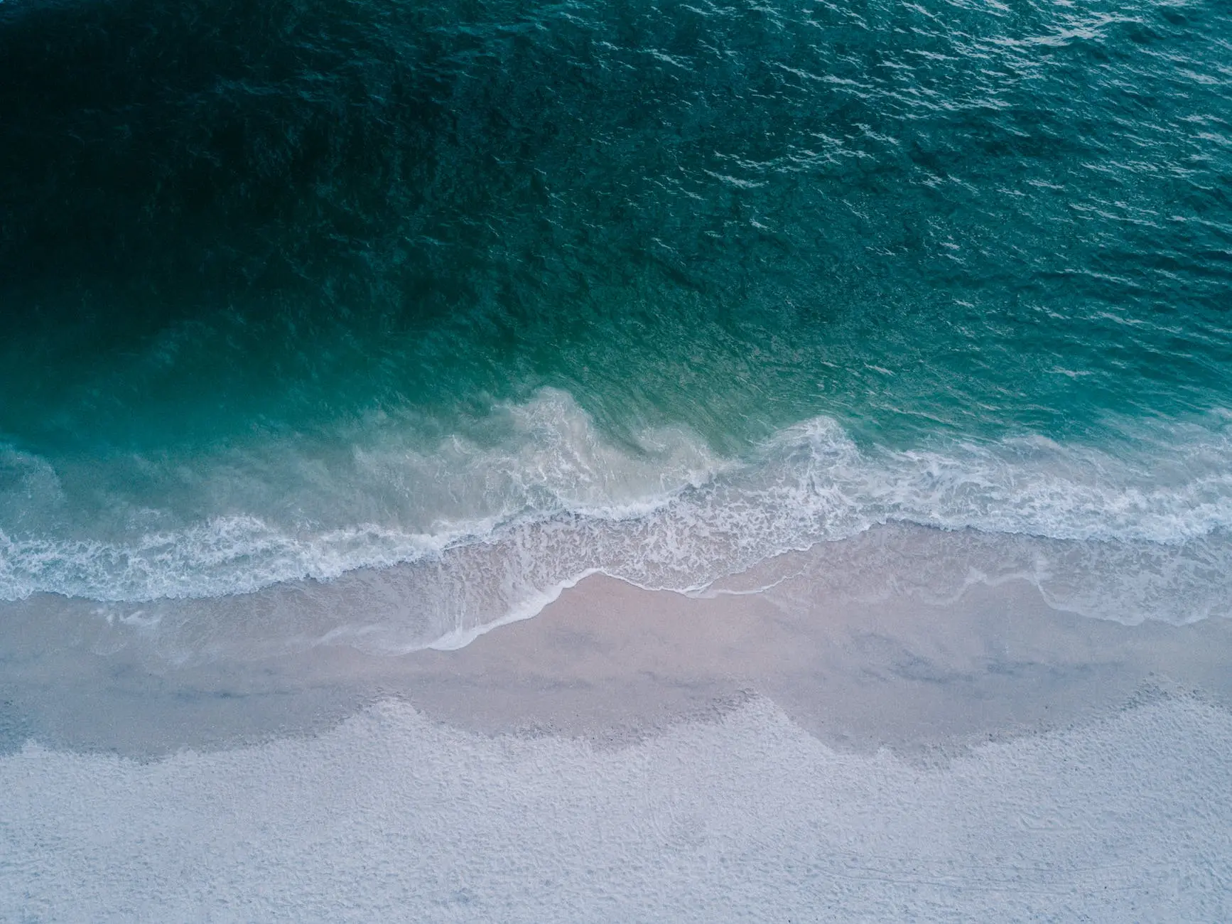 body of water beside beach sand